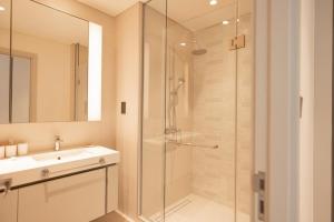 a bathroom with a glass shower and a sink at Exquisite 2BR in Sunrise bay at Emaar Beachfront in Dubai