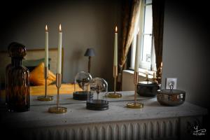 una mesa con velas en la parte superior con una mesa con una mesa en Manoir Marceau, en Vieil-Hesdin