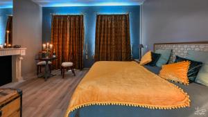1 dormitorio con 1 cama grande y paredes azules en Manoir Marceau, en Vieil-Hesdin