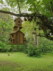 una casa de pájaros colgando de un árbol en un parque en Manoir Marceau, en Vieil-Hesdin
