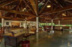 a living room with couches and tables in a building at Rhythm Kumarakom in Kumarakom
