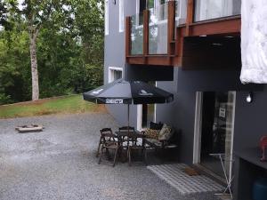 eine Terrasse mit einem Tisch und Stühlen unter einem Sonnenschirm in der Unterkunft Hostel SIL CARDOSO in Blumenau