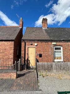 an old brick house with a yellow door at Studio Apartment Great Location in Swadlincote