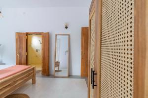 a room with a bedroom with a door and a mirror at NETS Cowork & Colive in Ahangama