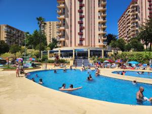 een groep mensen in het zwembad van een resort bij Apartments Benalmadena in Benalmádena