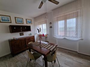 jadalnia z drewnianym stołem i krzesłami w obiekcie Le Logge Apartment w mieście Baratti