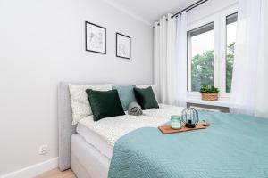 una camera bianca con un letto e una finestra di Apartament Nowy Świat 15-17 a Kalisz