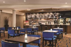 ソールズベリーにあるコー​​トヤード バイ マリオット ソールズベリーのテーブルと青い椅子のあるレストラン、バー