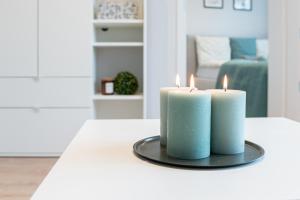 two candles sitting on a table in a living room at Apartament Nowy Świat 15-17 in Kalisz