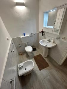 a white bathroom with a sink and a toilet at Case Vacanze Seggettieri in Palermo
