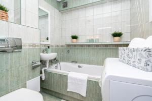 bagno con vasca, lavandino e servizi igienici di Apartament Nowy Świat 15-17 a Kalisz
