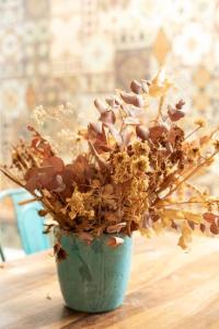 a green vase filled with dried flowers on a table at Luxury Villa by the Beach in Neve Tzedek's Heart! in Tel Aviv