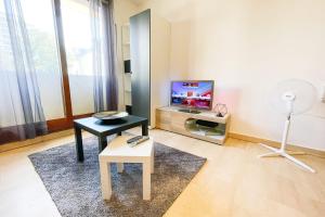 a living room with a table and a tv at The Grenoble Break #FQ in Grenoble