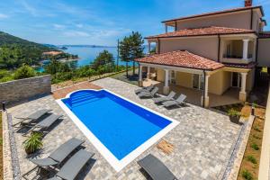 a villa with a swimming pool in front of a house at Apartments Mia in Sveti Juraj