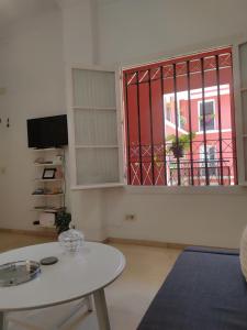 ein Wohnzimmer mit einem Tisch und einem Fenster in der Unterkunft PISO 2 HABITACIONES SEVILLA CENTRO WIFI in Sevilla