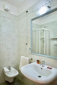 uma casa de banho com um lavatório e um espelho em ISA-Residence with swimming-pool at only 450 meters from the beach em Mazzanta