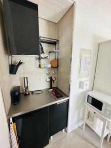a small kitchen with a counter and a microwave at appartme. XS in Bad Herrenalb