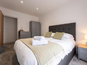 sypialnia z dużym łóżkiem z dwoma ręcznikami w obiekcie Pass the Keys Modern Apartment with Terrace w mieście Telford