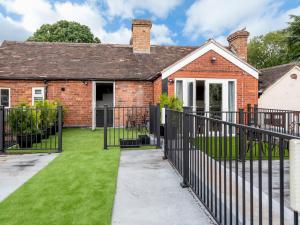 a brick house with a black iron fence at Pass the Keys Modern Apartment with Terrace in Telford