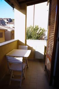 uma mesa e cadeiras numa varanda com uma janela em Beach House em Piombino