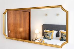 a mirror reflecting a bed in a bedroom at Wine Apartments in Porto