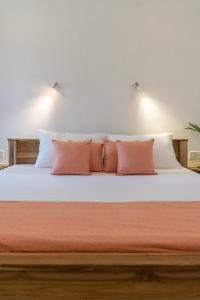 a bed with white sheets and orange pillows at NETS Cowork & Colive in Ahangama