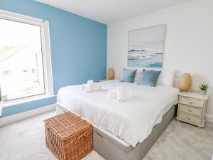 a bedroom with a large bed with blue walls and a window at Lyme View in Portland