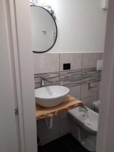 y baño con lavabo blanco y espejo. en Affitta Camere La Turandot en Génova