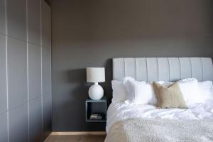 1 dormitorio con cama blanca y mesita de noche con lámpara en Villa Sara en Landvetter