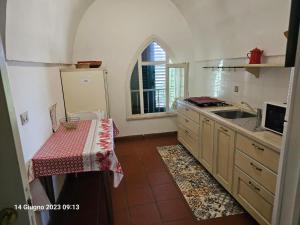 una cucina con tavolo, lavandino e finestra di Gecko's House a Villaggio Resta