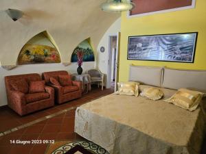 una camera con letto, divano e sedie di Gecko's House a Villaggio Resta