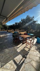 una mesa de picnic y sillas en un patio de piedra en Elaiocampus luxury house, en Kamáres