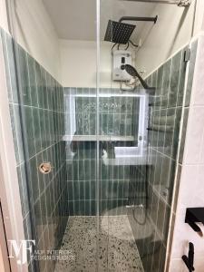 a bathroom with a shower with a glass door at Mi Casa in Manila