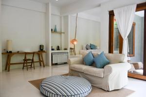 a living room with a white couch and blue pillows at Proud Phu Fah Hip & Green Resort in Mae Rim