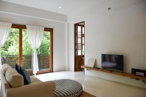 a living room with a couch and a flat screen tv at Proud Phu Fah Hip & Green Resort in Mae Rim