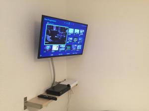 telewizor z płaskim ekranem wiszący na ścianie w obiekcie Apartment Villeurbanne w mieście Villeurbanne