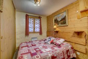- une chambre dotée d'un lit avec une couverture rouge et blanche dans l'établissement La Tanière du Grizzly - Appt à Praz-sur-Arly, à Praz-sur-Arly