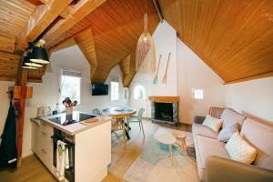 Una cocina y una sala de estar con un sofá y una mesa. en Marée Haute et Marée Basse - 1 Appartement et 1 Studio proche de la plage, en Barneville-Carteret