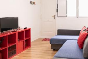 una sala de estar con un centro de entretenimiento rojo con TV de pantalla plana en La Monimba, en La Laguna