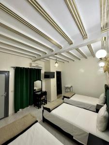 - une chambre avec 2 lits et un bureau dans l'établissement Hôtel Zaghro, à Ouarzazate