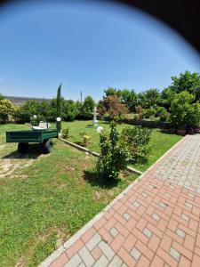 un jardin avec un banc vert dans la pelouse dans l'établissement Casale Bianco al casello dell' autostrada Guidonia, à Guidonia