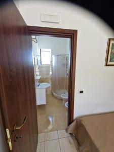 Cette chambre comprend une salle de bains avec des toilettes et une porte. dans l'établissement Casale Bianco al casello dell' autostrada Guidonia, à Guidonia