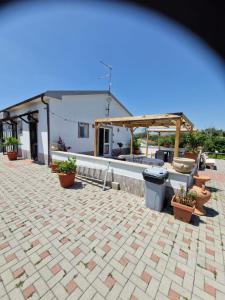 un patio avec des plantes en pot et un bâtiment dans l'établissement Casale Bianco al casello dell' autostrada Guidonia, à Guidonia