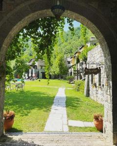 an archway leading into a park with a pathway at Mantania Tower in Kalabaka