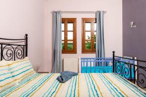 ein Schlafzimmer mit einem Bett und einem Fenster in der Unterkunft The backyard- Κατοικία στην Αγριά, Βόλου in Agria