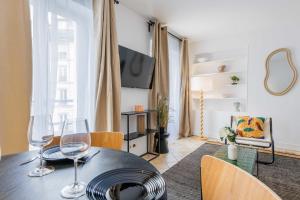 uma sala de jantar com uma mesa e dois copos de vinho em Amazing and cosy apartment rue des Petites Ecuries 4P1BR em Paris