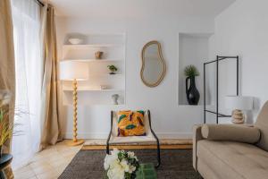 uma sala de estar com um sofá e uma cadeira em Amazing and cosy apartment rue des Petites Ecuries 4P1BR em Paris