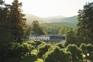 a large house in the middle of a garden at Waldhaus Flims Wellness Resort, Autograph Collection in Flims