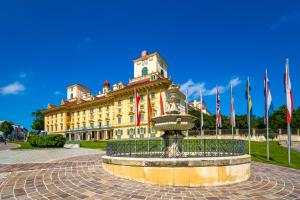 um edifício amarelo com uma fonte em frente em St. Antoni Suite 5 em Eisenstadt