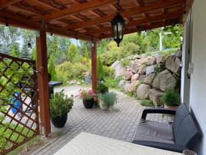 a patio with a bench and a stone wall at Biały Domek, noclegi Gołdap in Gołdap